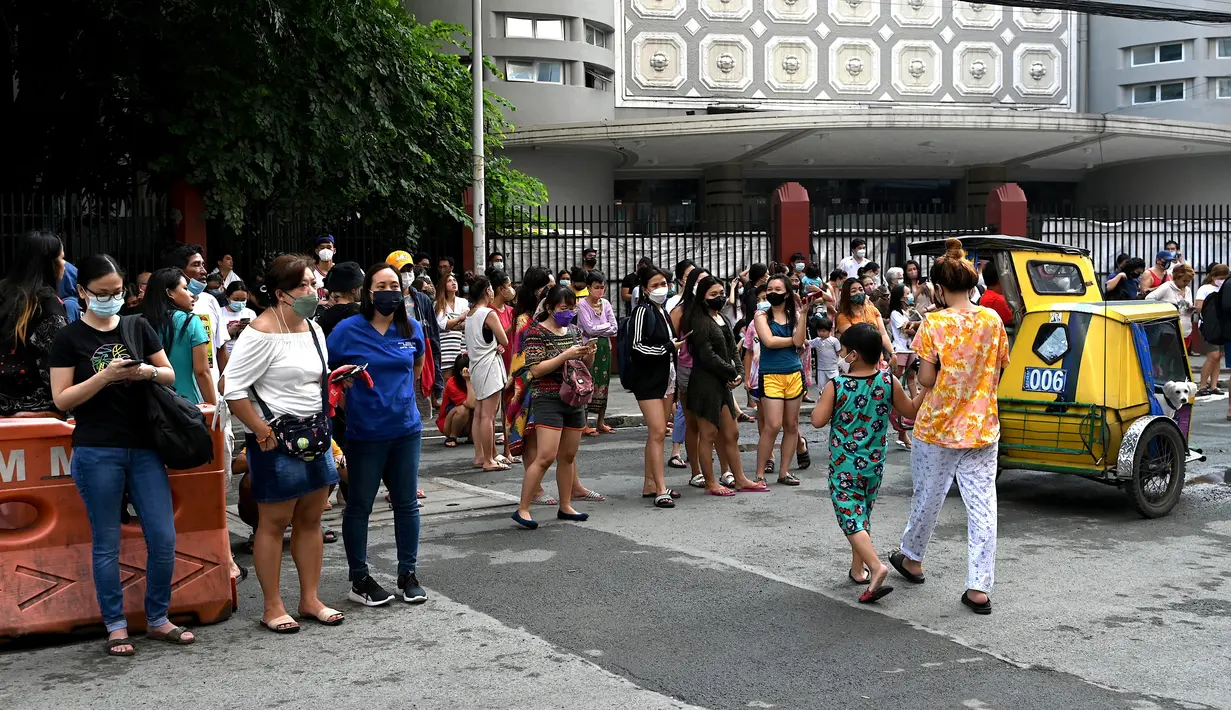 Warga menyelamatkan diri dengan keluar bangunan setelah gempa berkekuatan magnitudo 7,1 terasa di Manila, Filipina, Rabu (27/7/2022). Gempa mengguncang wilayah Dolores, Filipina. (JAM STA ROSA/AFP)