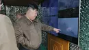 Dalam foto yang disediakan oleh pemerintah Korea Utara, pemimpin Korea Utara Kim Jong Un (kanan) mengawasi latihan serangan balik nuklir virtual dengan unit "roket artileri" yang besar, di sebuah tempat yang dirahasiakan di Korea Utara pada Senin, 22 April 2024. (STR / KCNA VIA KNS / AFP)