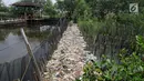 Papan jalan setapak tertutup tumpukan sampah di kawasan hutan mangrove, Muara Angke, Jakarta Utara, Sabtu (14/4). Sampah yang mayoritas dari limbah domestik rumah tangga itu berdampak buruk bagi ekosistem di lingkungan sekitar. (Liputan6.com/Johan Tallo)