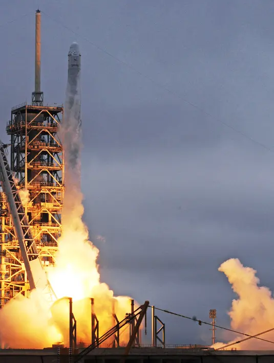 Roket Falcon 9 milik SpaceX mengeluarkan semburan api jelang meluncur dari landasan 39A, Kennedy Space Center, Florida, AS, Minggu (19/2). Dikabarkan roket Falcon 9 itu berhasil mendarat kembali ke tempat awal. (AFP PHOTO / BRUCE WEAVER) 