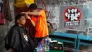 Warga saat mengikuti cukur gratis yang diselenggarakan oleh Relawan Jokowimotion di Cakung, Jakarta Timur, Sabtu (13/10). Ratusan warga berkumpul antusias untuk mengikuti acara cukur gratis ini. (Liputan6.com/Andy)