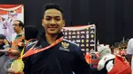 Ahmad Zigi Zaresta memamerkan medali yang diperoleh di nomor Junior Kata Male di WKF World Junior, Cadet and U-21 Championship 2015 di ICE Serpong, Banten, Kamis (12/11/2015). Zigi menyumbang emas pertama bagi Indonesia. (Liputan6.com/Helmi Fithriansyah)