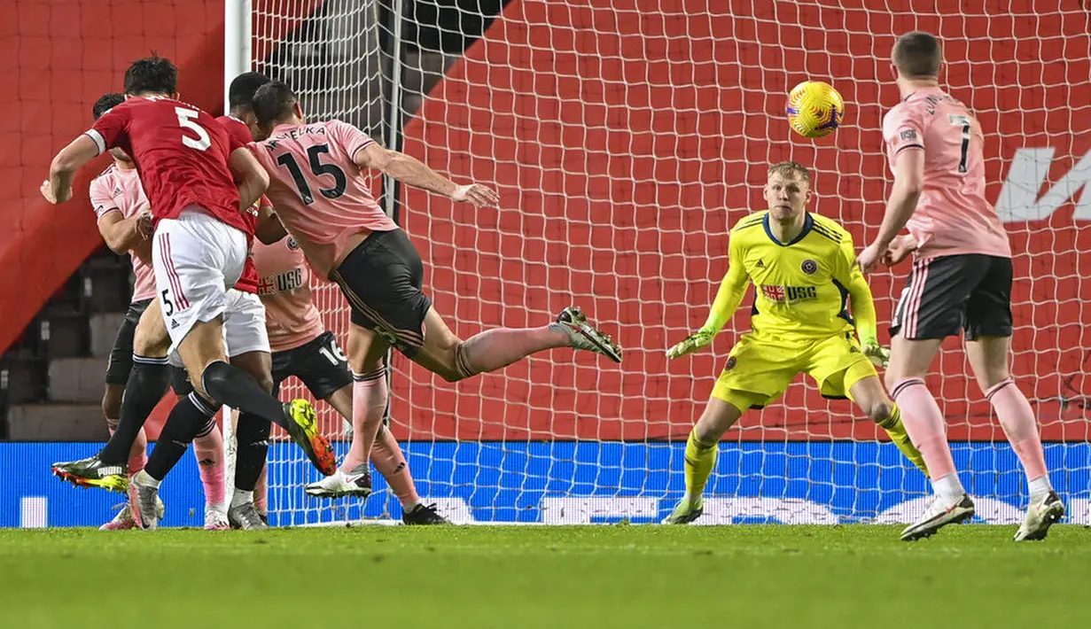 Bek Manchester United, Harry Maguire, mencetak gol ke gawang Sheffield United pada laga Liga Inggris di Stadion Old Trafford,  Kamis (28/1/2021). MU takluk dengan  skor 1-2. (AP/Laurence Griffiths,Pool)