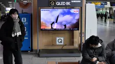 Seorang perempuan berjalan melewati layar televisi yang menayangkan siaran berita dengan rekaman file uji coba rudal Korea Utara, di sebuah stasiun kereta api di Seoul, Sabtu (31/12/20220). Korea Utara menutup akhir tahun 2022 dengan menembakkan tiga rudal balistik jarak pendek pada hari Sabtu, kata militer Korea Selatan. (Jung Yeon-je / AFP)