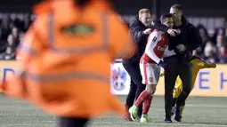 Fans yang masuk ke lapangan memeluk dan mencium pemain Arsenal, Alexis Sanchez saat laga putaran kelima Piala FA di Gander Green Lane stadium, (20/2/2017). Arsenal menang 2-0. (AP/Matt Dunham)