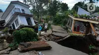 Santri Pesantren Al Burok melintasi jalan yang hancur akibat gempa di , Kampung Cisarua, Desa Sarampad, Cianjur, Jawa Barat, Rabu (21/11/2022). Gempa bumi dengan magnitude 5,6 di Cianjur Jawa Barat yang berpusat di darat 10 km barat daya embuat sejumlah rumah dan bangunan rusak. (merdeka.com/Arie Basuki)