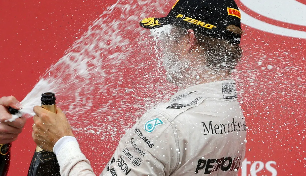 Wajah Rosberg terkena semprotan sampanye pada saat selebrasi kemenangannya pada seri ke-17 Formula One (F1) GP Jepang, Minggu (9/10). Rosberg bertahan berada di posisi terdepan dari awal hingga akhir balapan. (REUTERS/Toru Hanai) 