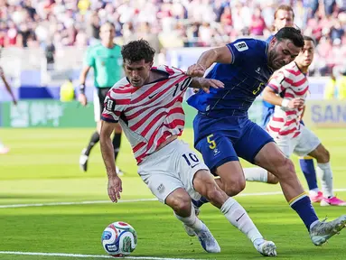 Pemain Amerika Serikat Christian Pulisic menggiring bola sementara pemain Bosnia Sead Kolasinac menarik bajunya selama pertandingan sepak bola babak 32 Piala Dunia antara Amerika Serikat dan Bosnia di Santa Clara, California, dekat San Francisco, Rabu, (01/07/2026). (AP Photo/Julio Cortez)