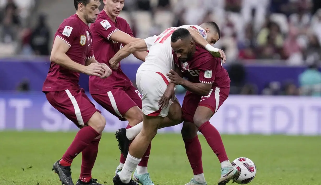 Pemain Lebanon, Omar Chaaban, berusaha melewati adangan pemain Qatar pada babak penyisihan Grup A Piala Asia 2023 di Stadion Lusail, Jumat (12/1/2024). (AP Photo/Aijaz Rahi)