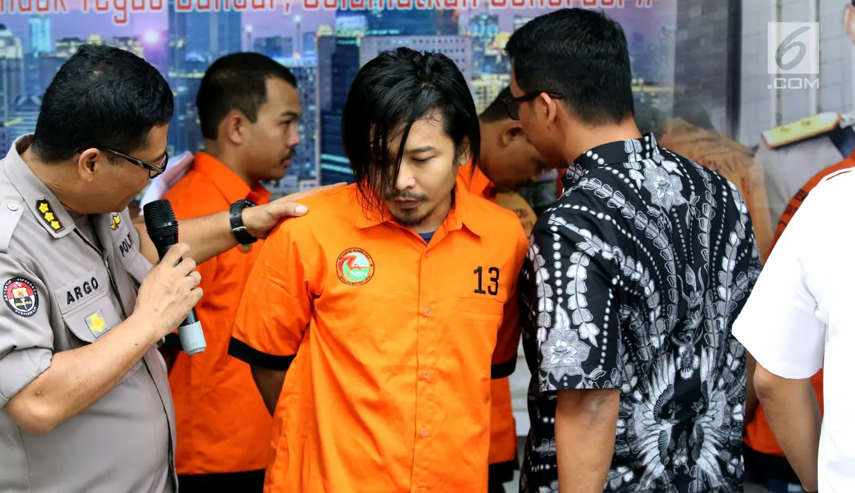 Vokalis grup band Zivilia, Zulkifli alias Zul (tengah) diperlihatkan petugas Ditresnarkoba Polda Metro Jaya, Jakarta, Jumat (8/3). Zul ditangkap terkait penyalahgunaan narkotika di kawasan Jakarta Utara, Kamis (28/2). (Liputan6.com/Helmi Fithriansyah)