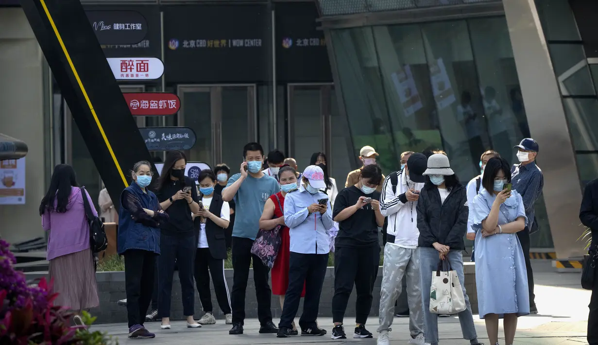 <p>Orang-orang yang memakai masker berbaris untuk tes COVID-19 pada hari ketiga berturut-turut dari pengujian virus corona massal di Beijing, Kamis (5/5/2022). Ibu kota China Beijing pada Kamis (5/5) mulai melonggarkan aturan karantina untuk kedatangan dari luar negeri. (AP Photo/Mark Schiefelbein)</p>