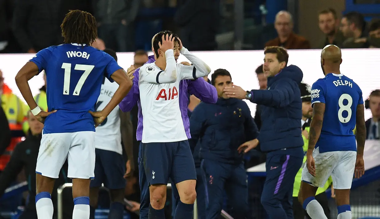 Striker Tottenham Hotspur Son Heung-min (tengah) memegangi kepalanya setelah menekel gelandang Everton Andre Gomes pada pertandingan Liga Inggris di Goodison Park, Liverpool, Inggris, Minggu (3/11/2019). Tekel Son Heung-min menyebabkan Andre Gomes patah kaki. (Oli SCARFF/AFP)