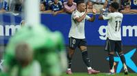 Penyerang Real Madrid asal Prancis #10, Kylian Mbappe, merayakan gol bersama penyerang Real Madrid asal Brasil #11 Rodrygo setelah mencetak gol pertama timnya dalam pertandingan Liga Spanyol antara Real Oviedo dan Real Madrid CF di Stadion Carlos Tartiere, Oviedo, Senin (25-8-2025) dini hari WIB. (Cesar MANSO/AFP)