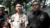Putra Presiden Joko Widodo, Gibran Rakabuming Raka didampingi Sekjen PDI Perjuangan Hasto Kristiyanto memberikan keterangan kepadaa awak media usai melakukan pertemuan dengan Ketum PDIP Megawati Soekarnoputri di Jalan Teuku Umar, Jakarta, Kamis (24/10/2019). (merdeka.com/Iqbal Nugroho)