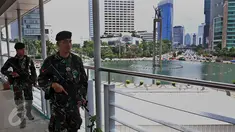 Aparat keamanan berjaga di jembatan penyeberangan orang (JPO) kawasan Bundaran HI, Jakarta, (5/3). Pengamanan dan Sterilisasi dilakukan jelang Konferensi Tingkat Tinggi Luar biasa Organisasi Kelompok Islam (KTT Luar Biasa OKI). (Liputan6.com/JohanTallo)