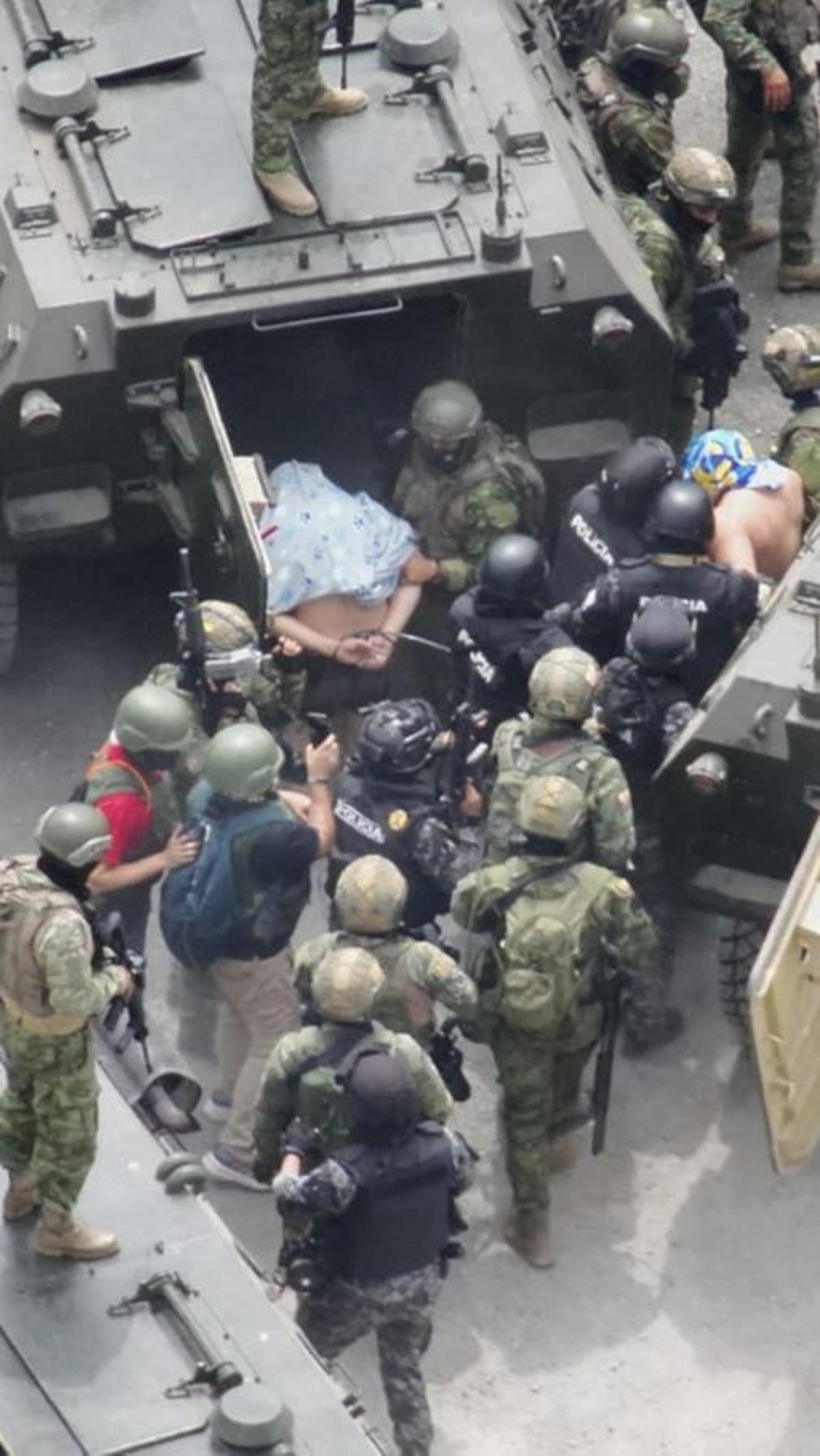 Tentara militer dan polisi tampak membawa pemimpin kriminal Jose Adolfo Macias Villamar, yang dikenal sebagai "Fito" ke dalam mobil lapis baja setelah diamankan dalam penggerebekan di penjara Zonal 8, di Guayaquil, Ekuador.