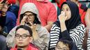 Saat sang rekan tengah asyik dengan gadgetnya, seorang suporter wanita Indonesia tampak tegang menyaksikan para pemain Timnas Indonesia U-17 berlaga kontra Timnas Panama U-17 pada laga kedua Grup A Piala Dunia U-17 2023 di Stadion Gelora Bung Tomo, Surabaya, Senin (13/11/2023). (Bola.com/Bagaskara Lazuardi)