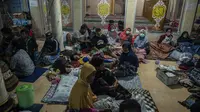 Pengungsi berlindung pasca erupsi Gunung Semeru di Masjid Desa Sumber Wuluh, Lumajang (5/12/2021). Warga pun diimbau menjauhi daerah sekitar sungai yang berhulu di Gunung Semeru. (AFP/Juni Kriswanto)