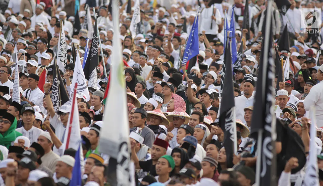 Umat muslim mengikuti aksi reuni 212 di kawasan silang Monas, Jakarta, Minggu (2/12). Bendera dan panji-panji terlihat diusung para peserta aksi reuni akbar 212. (Liputan6.com/Herman Zakharia)