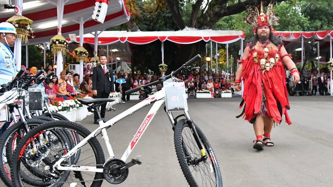 Yusak Rumambi yang mengenakan pakaian khas Minahasa mendapat hadiah sepeda dari Presiden Joko Widodo (foto: Biro Pers Kepresidenan)