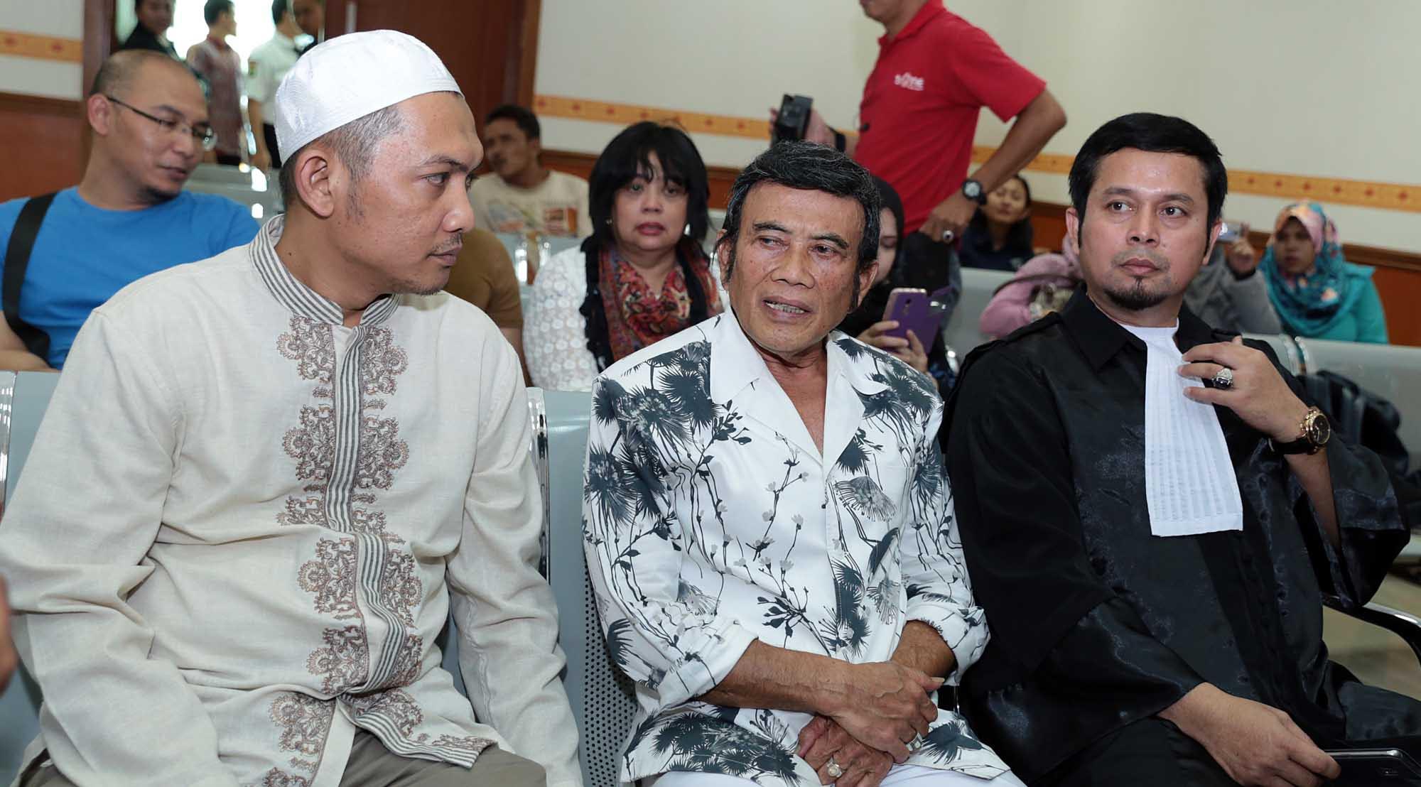 Turut hadir dalam sidang kali ini ayahnya, Rhoma Irama berbalut kemeja putih bermotif splash hitam. Ayah Ridho duduk di bangku pengunjung sidang deretan paling depan. (Deki prayoga/Bintang.com)