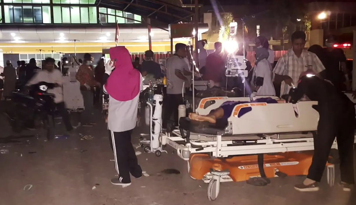 Sejumah perawat, dokter dan pasien berada diluar rumah sakit saat gempa mengguncang Lombok Utara, NTB Minggu malam (5/8). Gempa berada pada titik 8.25 LS, 116.49 BT, atau sekitar 27 km Timur Laut Lombok Utara, NTB. (AFP Photo/Rita Siswati)