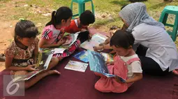 Sejumlah anak membaca buku di halaman Rusun Cipinang Besar Selatan, Jakarta, Rabu (27/4). Pemprov DKI Jakarta melengkapi fasilitas rusun tersebut berupa perpustakaan dan taman bermain anak. (Liputan6.com/Gempur M Surya)