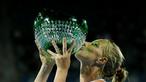 Petenis putri Rusia, Svetlana Kuznetsova, mencium trofi juara turnamen tenis Sydney International setelah di final mengalahkan petenis Puerto Rico, Monica Puig, Minggu (16/1/2016). (Reuters/Jason Reed)