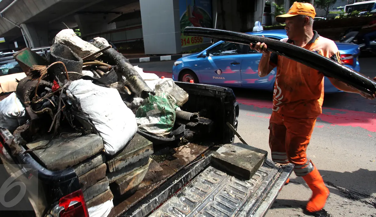Petugas membawa kulit kabel dari dalam gorong-gorong Jalan Gatot Subroto, Jakarta ke sebuah mobil bak, Senin (6/3). Kulit kabel ini dianggap menjadi penyebab utama terjadinya banjir di Jalan Gatot Subroto pada 2 Maret 2017 lalu. (Liputan6.com/Johan Tallo)