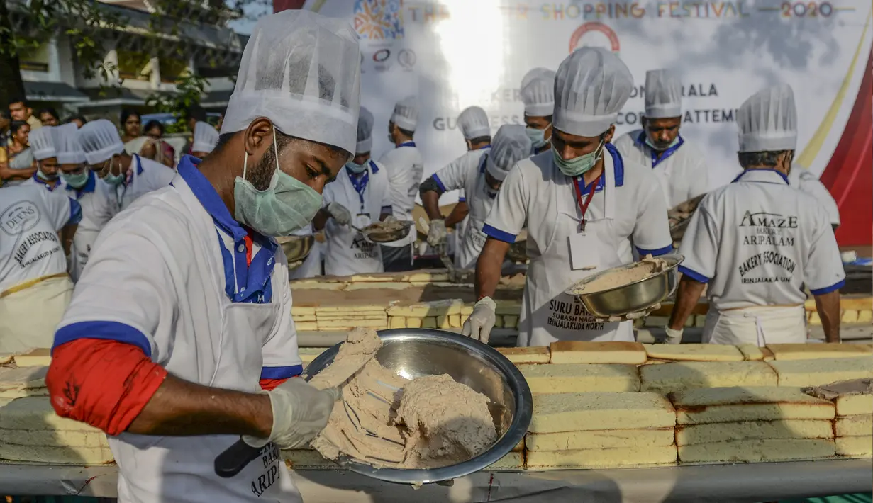 Pembuat roti dan koki menyiapkan kue sepanjang 6,5 km untuk kue terpanjang dunia, di Thrissur di negara bagian Kerala, India selatan (15/1/2020). Sebelumnya rekor Guinness World Record untuk kue terpanjang diraih di China degan panjang 3,2 kilometer. (AFP/Arun Sankar)