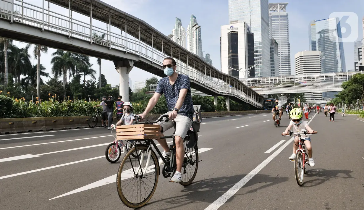 Warga berolahraga saat kegiatan Car Free Day (CFD) di Kawasan Sudirman, Jakarta, Minggu (21/6/2020). Pada CFD pertama di masa PSBB Transisi, warga Ibu Kota terlihat lebih memilih bersepeda sebagai sarana olahraga dengan tetap menerapkan protokol kesehatan Covid-19. (merdeka.com/Iqbal Nugroho)