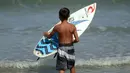 Natan Bontje selama latihan di pantai Kuta dekat Denpasar di pulau resor Indonesia Bali (6/5). Natan berusia sembilan tahun merupakan peserta termuda yang mengikuti kompetisi Asian Surfing Tour 2018 yang telah berakhir. (AFP Photo/Sonny Tumbelaka)