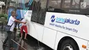 Suporter Persija, Jakmania, mencuci bus transjakarta di kantor PT Transjakarta, Jakarta, Kamis (13/12). Hal tersebut bentuk tanggung jawab atas aksi vandalisme oknum suporter saat Persija meraih Juara Liga 1 2018. (Liputan6.com/Immanuel Antonius)