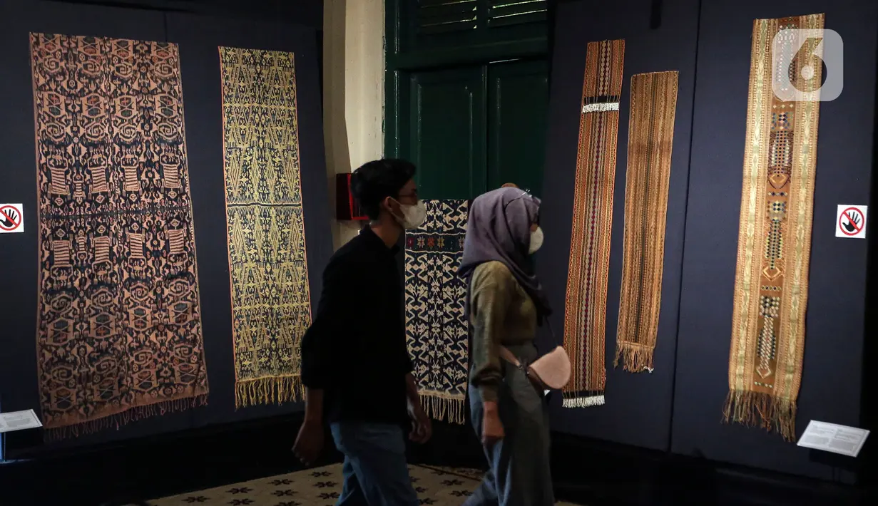 Pengunjung melihat kain tenun di pameran tenun bertajuk "Nuansa Kemilau Wastra Tenun Indonesia" di Museum Tekstil, Jakarta, Rabu (20/7/2022). Pameran dalam rangka memperingati HUT ke - 77 RI ini berlangsung hingga 31 agustus 2022 mendatang dan menampilkan kerajinan tenun dari Sumatera, Sulawesi, dan Timor. (Liputan6.com/Johan Tallo)