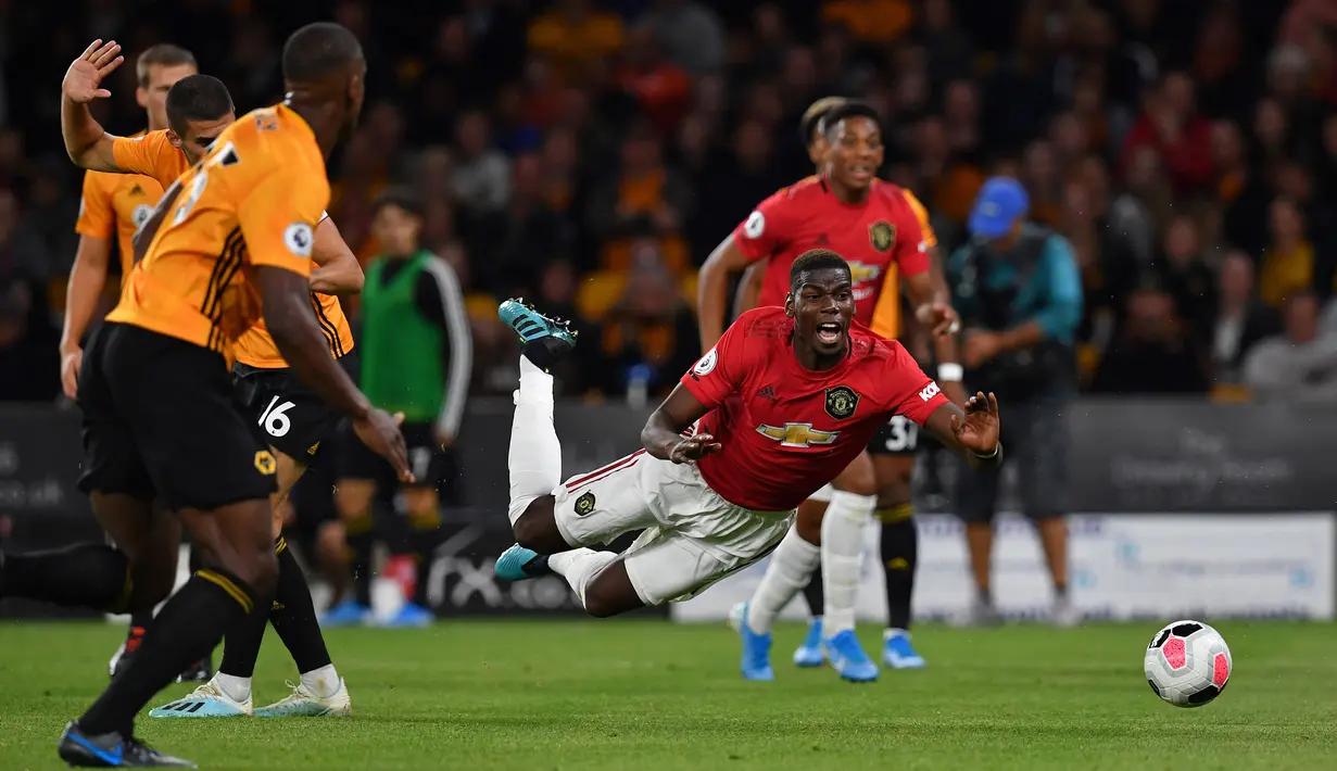Gelandang Manchester United Paul Pogba dilanggar oleh bek Wolverhampton Wanderers Conor Coady dalam kotak penaldi saat bertanding dalam Liga Inggris di Stadion Molineux, Wolverhampton, Inggris, Senin (19/8/2019). Pertandingan berakhir 1-1. (Paul ELLIS/AFP)