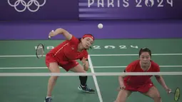 Pemain ganda putri China, Chen Qingchen (kiri) berusaha mengembalikan bola drive saat menghadapi wakil Indonesia, Apriyani Rahayu/Siti Fadia Silva Ramadhanti pada laga kedua Grup A nomor ganda putri cabor bulu tangkis Olimpiade Paris 2024 di Porte de la Chapelle Arena, Prancis, Minggu (28/7/2024). (AP Photo/Kin Cheung)