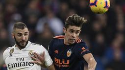 Striker Real Madrid, Karim Benzema, berebut bola dengan bek Valencia, Gabriel Paulista, pada laga La Liga di Stadion Santiago Bernabeu, Madrid, Sabtu (1/12). Madrid menang 2-0 atas Valencia. (AFP/Oscar Del Pozo)
