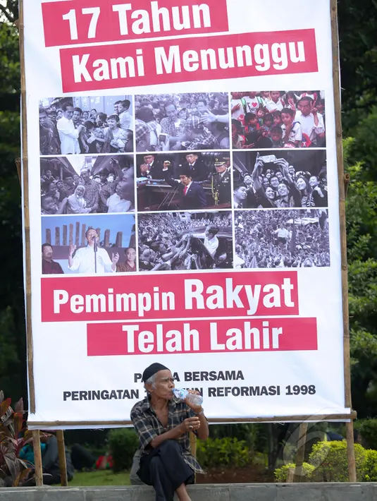 Warga duduk di depan spanduk yang berisi dukungan terhadap Jokowi, di sekitar Tugu Proklamasi, Jakarta, Kamis (21/5/2015). Spanduk tersebut dipasang dalam rangka memperingati 17 tahun reformasi. (Liputan6.com/Faizal Fanani)