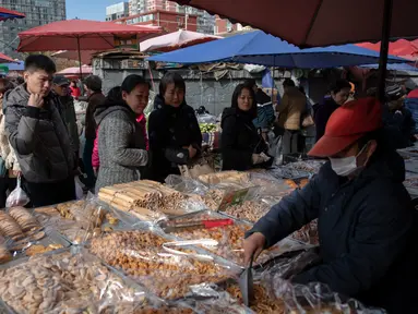 Sejumlah orang mengantre saat berbelanja kue di pasar di Beijing (20/11).  (AFP Photo/Nicolas Asfouri)