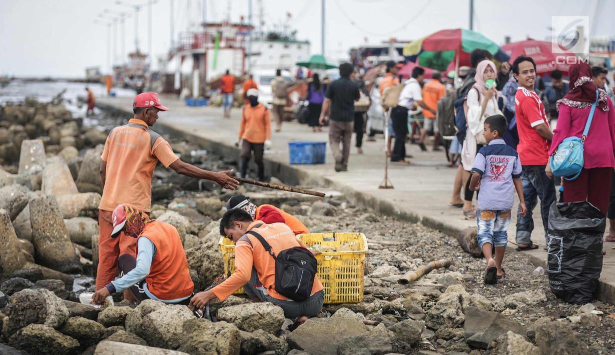 Petugas kebersihan membersihkan sampah laut di Pelabuhan Kali Adem, Jakarta, Senin (1/1). Banyaknya sampah plastik dibandingkan ikan yang gagal dikelola dengan baik membuat limbah yang mengakibatkan laut tercemar.  (Liputan6.com/Faizal Fanani)