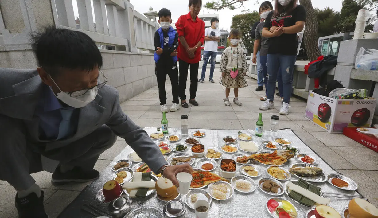 Pembelot Korea Utara Han Hong-geun (kiri)dan anggota keluarganya memberikan penghormatan kepada leluhur mereka di Korea Utara saat merayakan Chuseok dekat perbatasan dengan Korea Utara di Paviliun Imjingak, Paju, Selatan Korea, Kamis (1/10/2020). (AP Photo/Ahn Young-joon)
