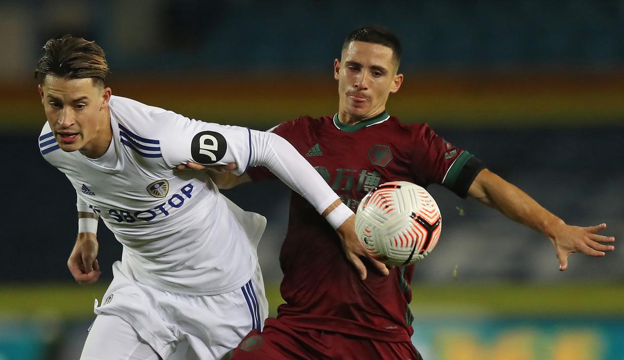 Gelandang Wolverhampton Wanderers, Daniel Podence, berebut bola dengan bek Leeds United, Robin Koch, pada laga Liga Inggris di Elland Road, Selasa (20/10/2020) dini hari WIB. Wolves menang 1-0 atas Leeds United. (AFP/Martin Rickett/pool)
