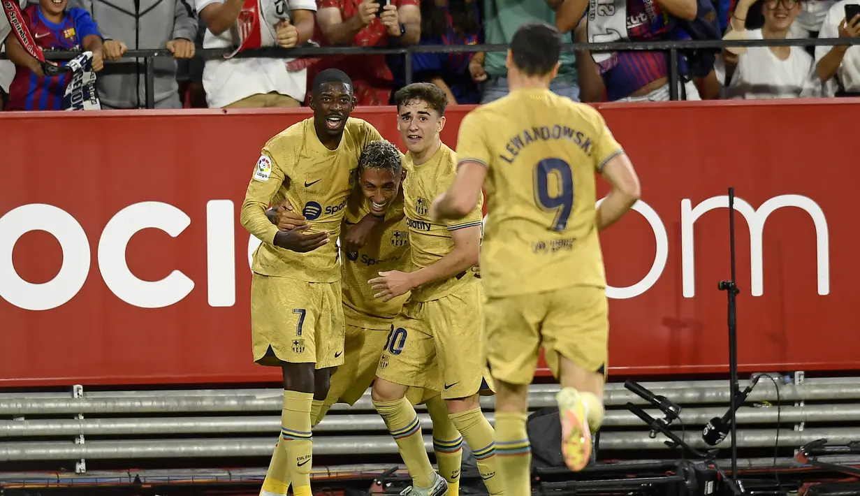Penyerang Barcelona, Raphinha (kedua kiri) berselebrasi dengan rekan satu timnya setelah mencetak gol ke gawang Sevilla pada pertandingan lanjutan La Liga Spanyol di Seville, Spanyol, Sabtu (3/9/2022). Barcelona menang telak atas Sevilla 3-0. (AP Photo/Jose Breton)