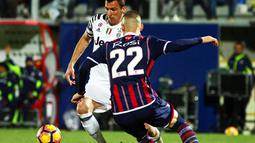 Striker Juventus, Mario Mandzukic, berusaha melewati pemain Crotone, Aleandro Rosi. Meski berstatus tamu, Juve lebih menguasai jalannya laga dengan penguasaan bola mencapai 76 persen. (EPA/Albano Angilletta)