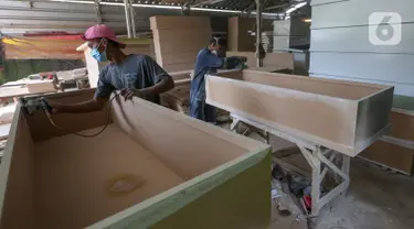 Pekerja menyelesaikan pembuatan peti mati Covid-19 di Rawa Mekar Jaya, Serpong, Tangerang Selatan, Kamis (21/01/2021). Produksi peti mati berbahan baku papan MDF meningkat cukup tinggi sejak bulan November 2020. (Liputan6.com/Fery Pradolo)