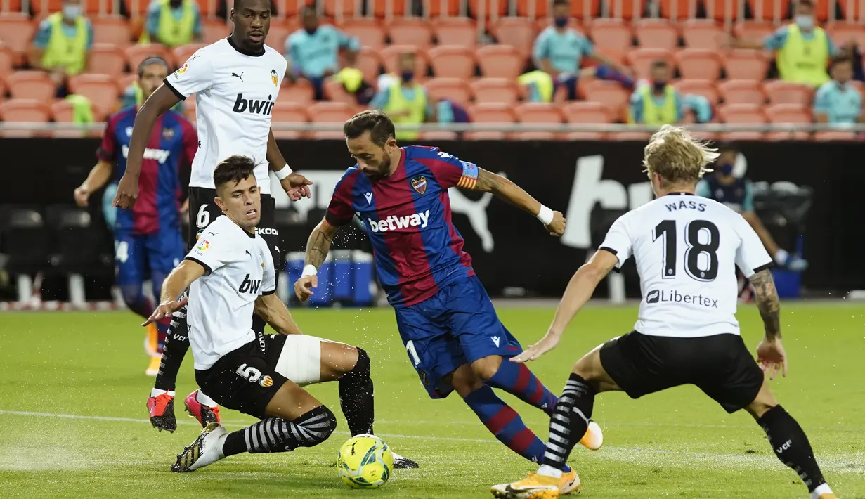 Pemain Levante, Jose Luis Morales berusaha melewati para pemain Valencia pada pertandingan La Liga Spanyol di Stadion Mestalla di Valencia, Spanyol, Minggu, (13/9/2020). Valencia menang telak 4-2. (AP Photo/Alberto Saiz)