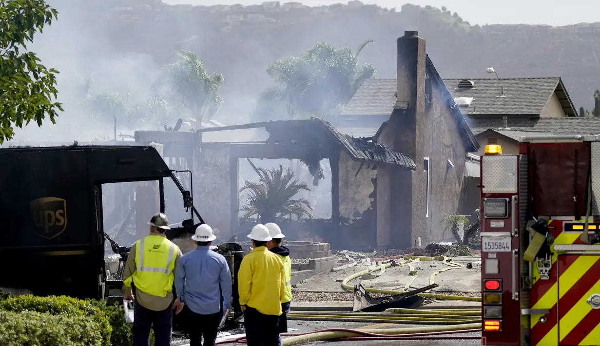 Petugas pemadam kebakaran dan tim SAR berada di lokasi jatuhnya sebuah pesawat kecil jatuh di Santee, California, Senin (11/10/2021). Pesawat Cessna bermesin ganda C340 itu sedang menuju ke Yuma, Arizona, dari Montgomery Field di San Diego. (AP Photo/Gregory Bull)