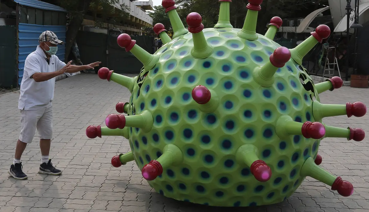 Desainer mobil India K. Sudhakar Yadav berdiri di samping mobil bertema Coronavirus di museum yang ia buat sebagai bagian dari kampanye kesadaran yang bertujuan mencegah penyebaran virus di Hyderabad, India, Selasa (7/4/2020). (AP Photo/Mahesh Kumar A.)