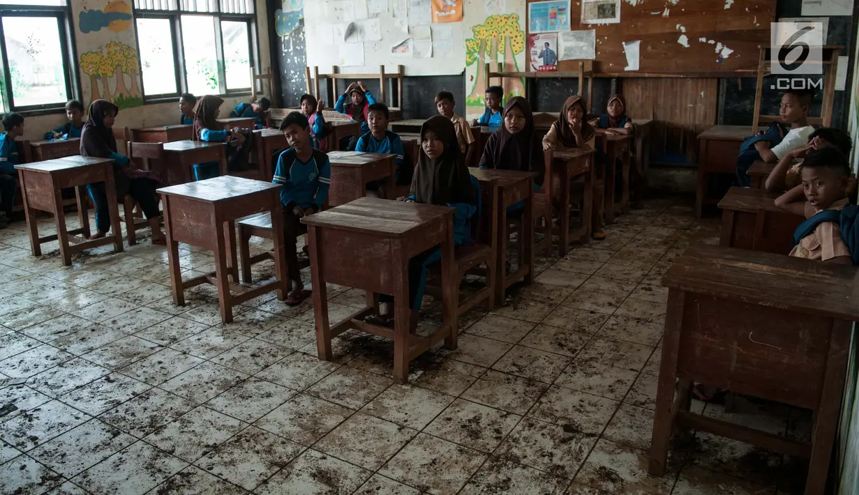 Suasana kegiatan belajar mengajar di SDN 04 Pantai Bahagia, Muara Gembong, Jawa Barat, Jumat (9/6). Kondisi kelas yang kotor akibat banjir rob menjadi rawan penyakit untuk siswa yang berada di ruangan tersebut. (Liputan6.com/Gempur M Surya)