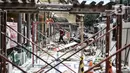 Pengguna kereta saat melintas di dekat pembangunan jalur pedestrian Stasiun Gondangdia, Jakarta Pusat, Kamis (8/4/2021). Stasiun Gondangdia akan menjadi salah satu stasiun terpadu yang pembangunannya meliputi penataan pedestrian, tempat khusus bagi pedagang. (merdeka.com/Iqbal S. Nugroho)